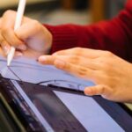 person using pencil to design on tablet scaled 1400x933 1